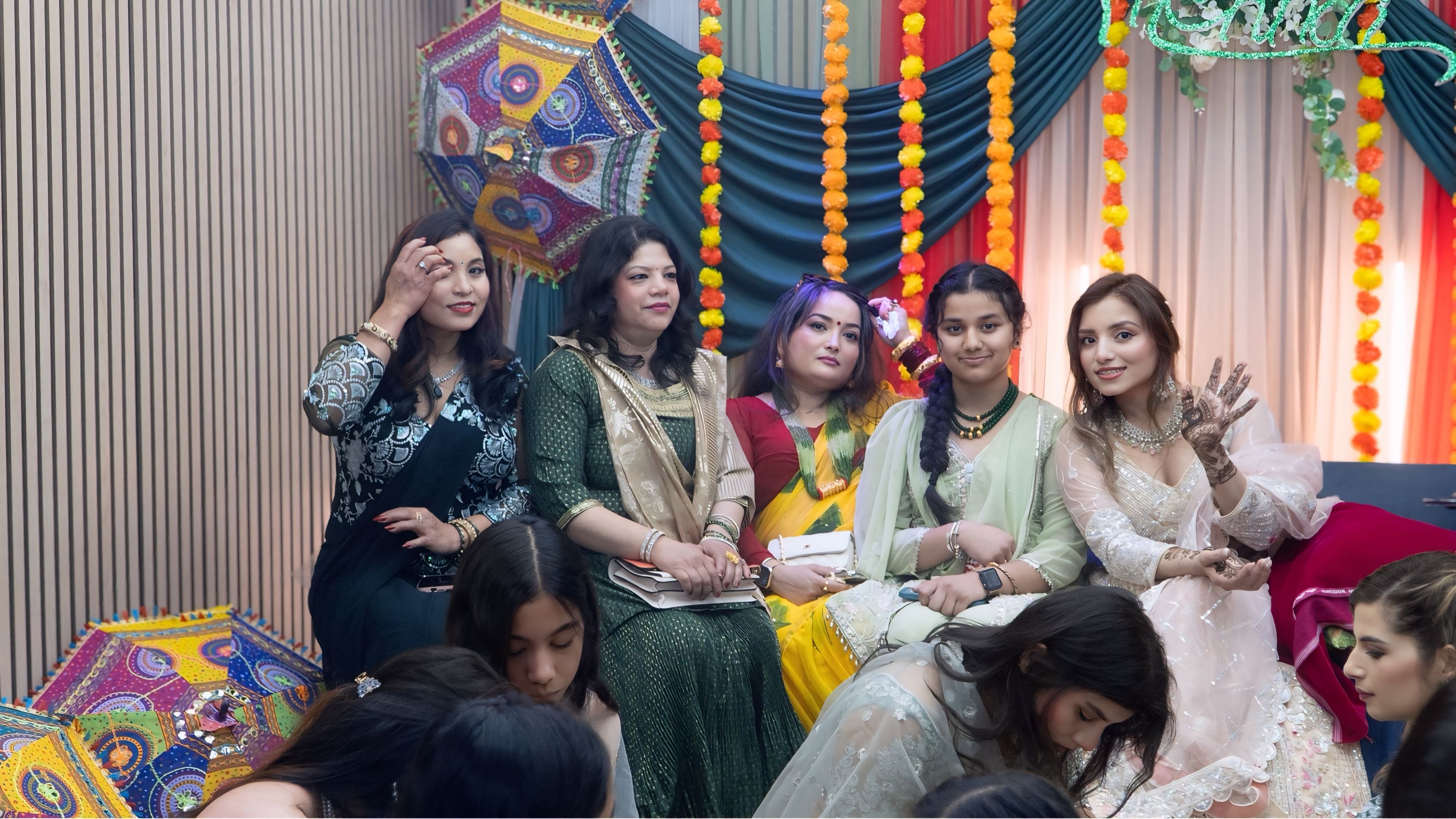 Large group photo at mehndi celebration — colorful South Asian wedding event